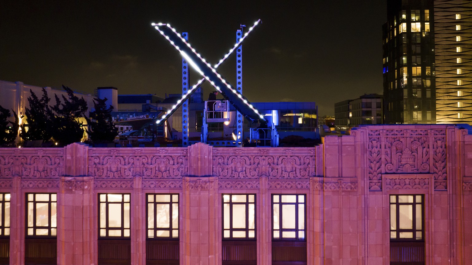 Workers install lighting on an &quot;X&quot; sign atop the company headquarters, formerly known as Twitter, in downtown San Francisco, on Friday, July 28, 2023. San Francisco has launched an investiga ...