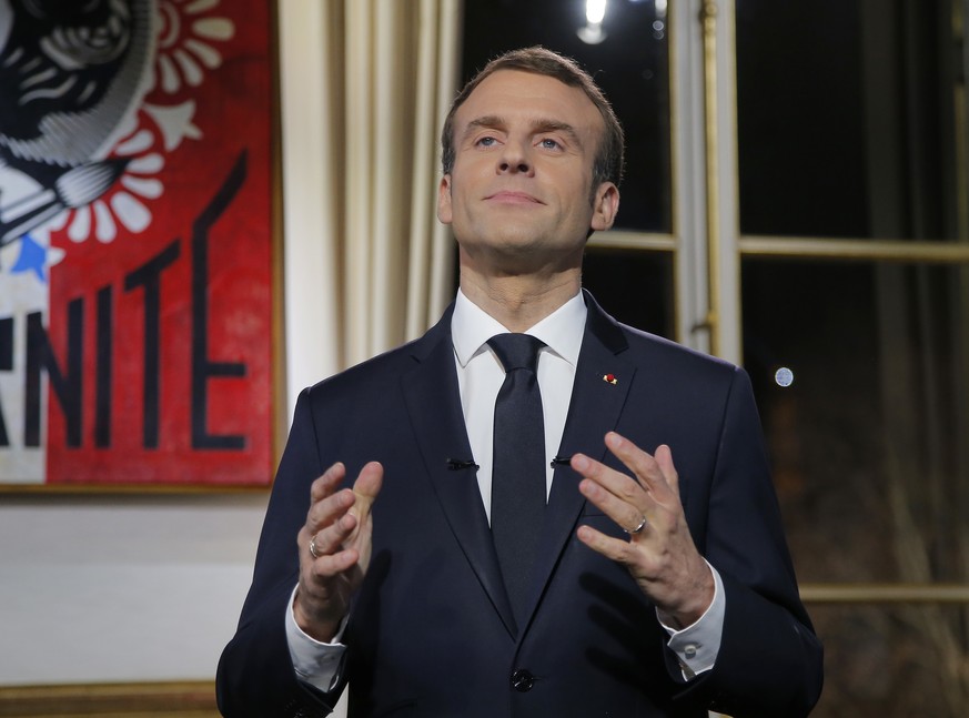 French President Emmanuel Macron, gestures as he poses for a photograph after the recording of his New Year&#039;s speech at the Elysee Palace, in Paris, Monday, Dec. 31, 2018. (AP Photo/Michel Euler, ...