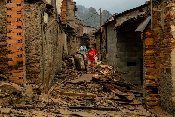 epa12308873 Residents search through rubble ravaged by an ongoing wildfire in San Vicente, Ourense province, Spain, 18 August 2025. EPA/BRAIS LORENZO