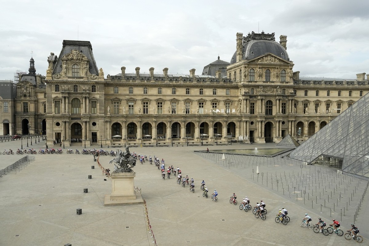 epa10764704 The peleton rides past the pyramid of the Louvre Museum during the 21st and final stage of the Tour de France 2023 over 115kms from Saint-Quentin-en-Yvelines to Paris Champs-Elysee, France ...