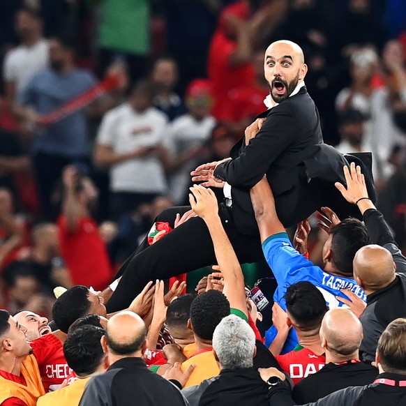 epaselect epa10359700 Morocco&#039;s head coach Walid Regragui (up) and his players celebrate after winning the FIFA World Cup 2022 quarter final soccer match between Morocco and Portugal at Al Thumam ...
