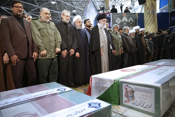 In this photo released by the official website of the Office of the Iranian Supreme Leader, supreme leader Ayatollah Ali Khamenei, center, leads a prayer over the coffins of Gen. Qassem Soleimani and  ...