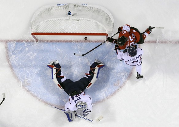 Alina Muller, of Switzerland, scores a goal against =South Korea&#039;s goalie Shin So-jung and South Korea&#039;s Park Ye-eun, of the combined Koreas team, during the first period of the preliminary  ...