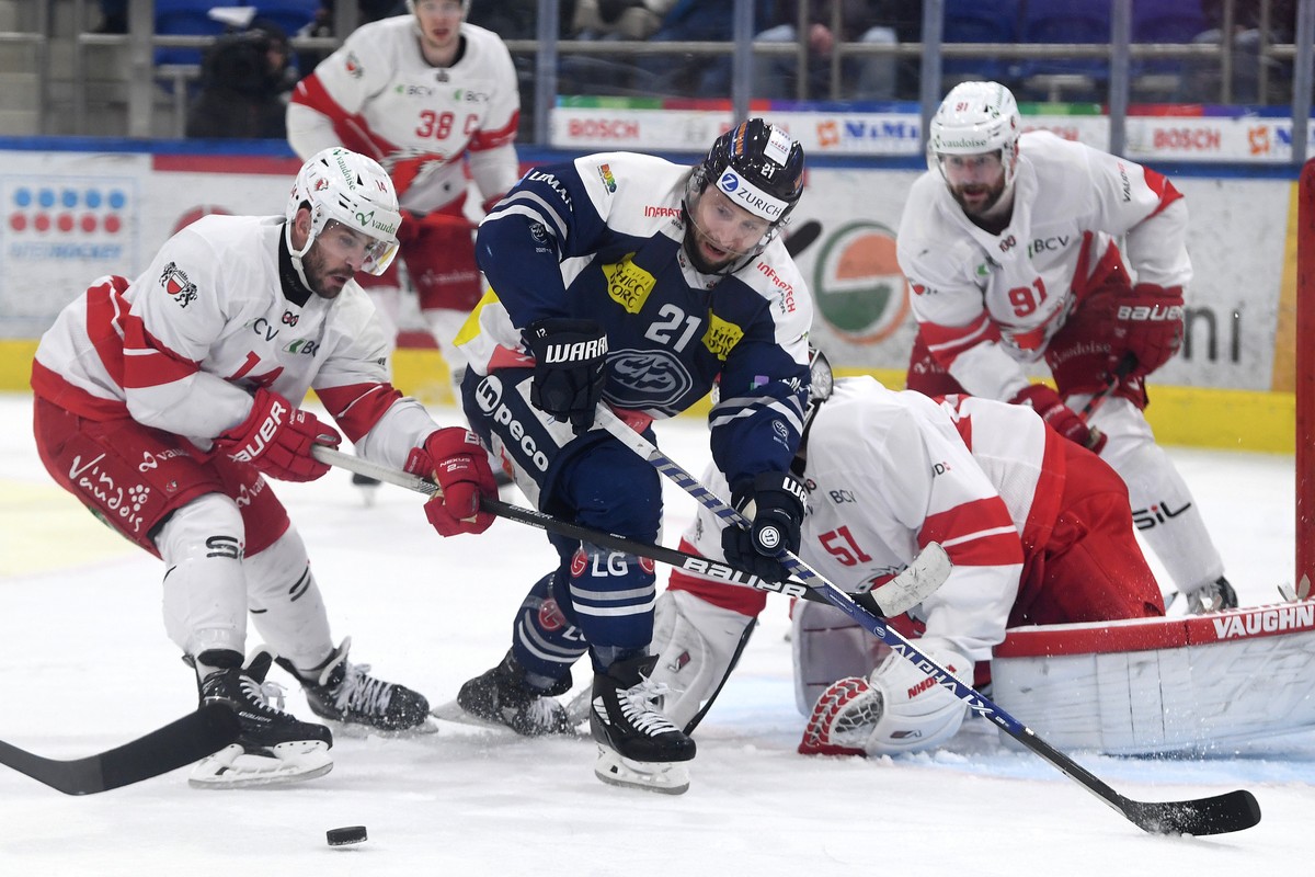 From left Lausanne's player Jason Fuchs, Ambri's player Brandon McMillan and Lausanne's goalkeeper Tobias Stephan, during the preliminary round game of National League 2021/22 between H ...
