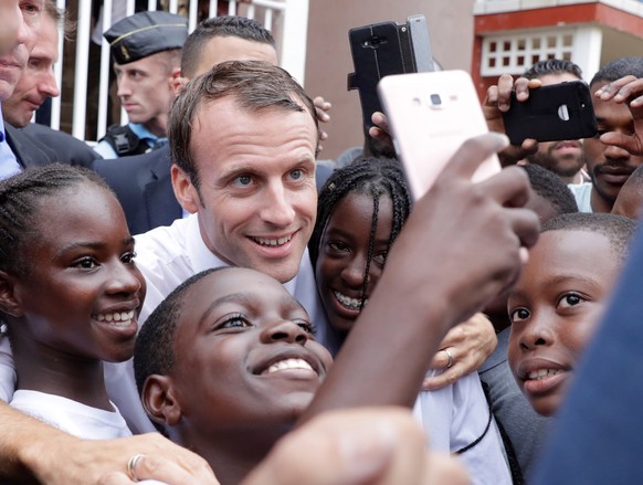 epa07059212 French president Emmanuel Macron takes sefies with children in Quartier d&#039;Orleans, 29 September 2018, (issued 30 September 2018 on the French Caribbean island of Saint-Martin, during  ...