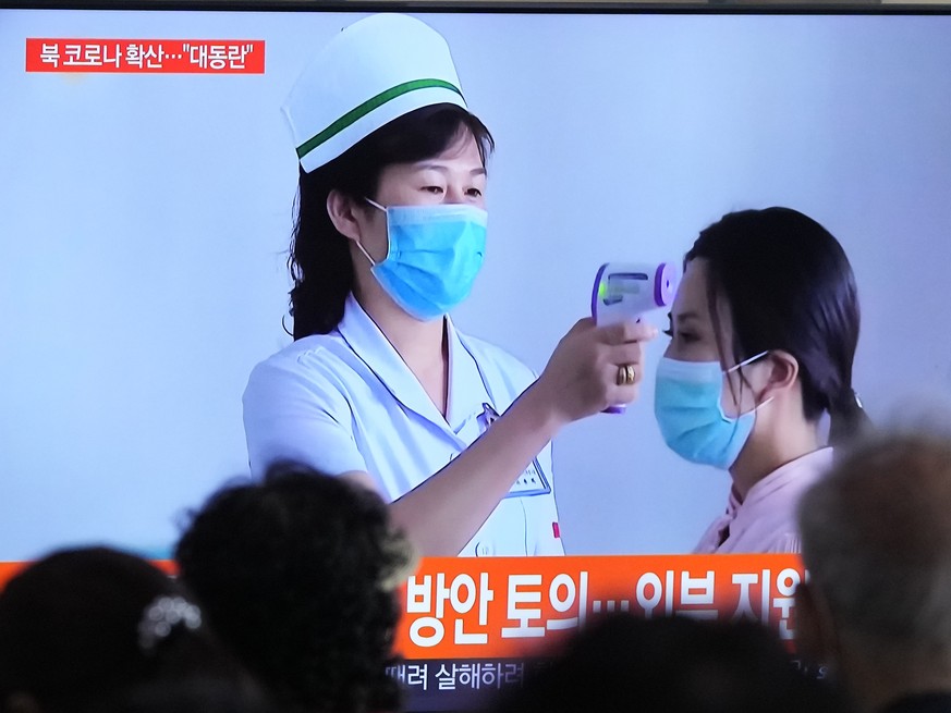 People watch a TV screen showing a news report about the COVID-19 outbreak in North Korea, at a train station in Seoul, South Korea, Saturday, May 14, 2022. North Korea on Saturday reported 21 new dea ...