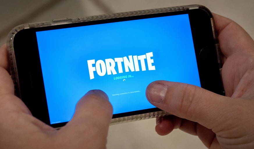 epa08621882 A person plays Fortnite on an iPhone in Miami, Florida, USA, 24 August 2020. US tech giant Apple and game developer Epic Games are in a dispute over the distribution of income from in-app  ...