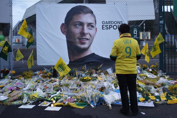FILE - In this Wednesday, Jan. 30, 2019, file photo, a Nantes soccer team supporters stops by a poster of Argentinian player Emiliano Sala and reading &quot;Let&#039;s keep hope&quot; outside La Beauj ...