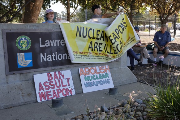 epa12287461 Protesters cover the Lawrence Livermore National Laboratory (LLNL) sign, known for its work in nuclear weapons design, stockpile stewardship, and nonproliferation efforts, as well as advan ...