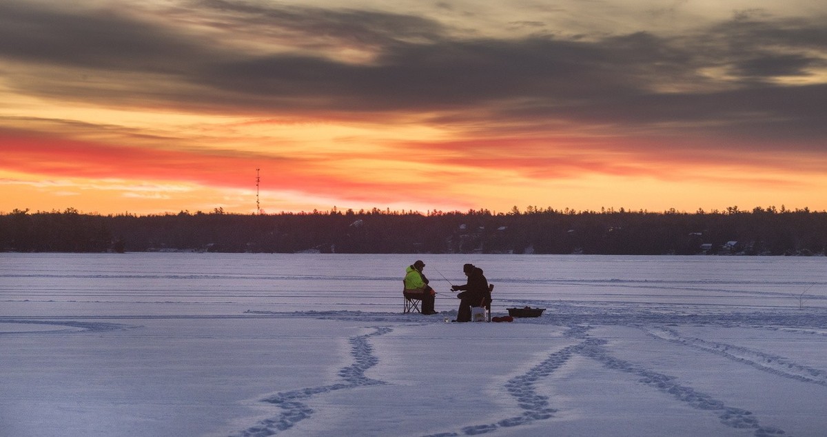 Anglers from Curve Lake First Nations bring in the dawn, ice fishing on Pigeon Lake in central Ontario's Kawartha Lakes, Sunday Jan. 24, 2021. (Fred Thornhill/The Canadian Press via AP)