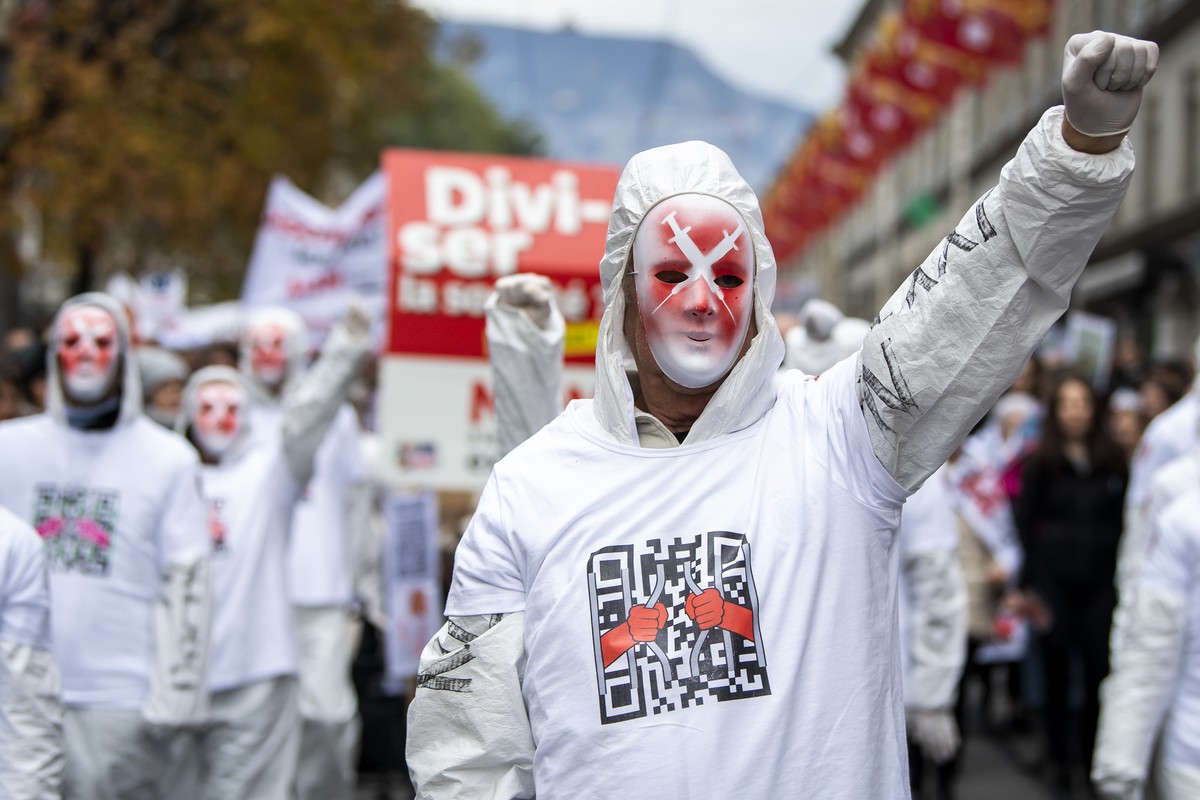 Des personnes manifestent contre la loi Covid-19 avec la presence des Freiheitstrychler lors d'un rassemblement le samedi 13 novembre 2021 a Geneve. (KEYSTONE/Jean-Christophe Bott)