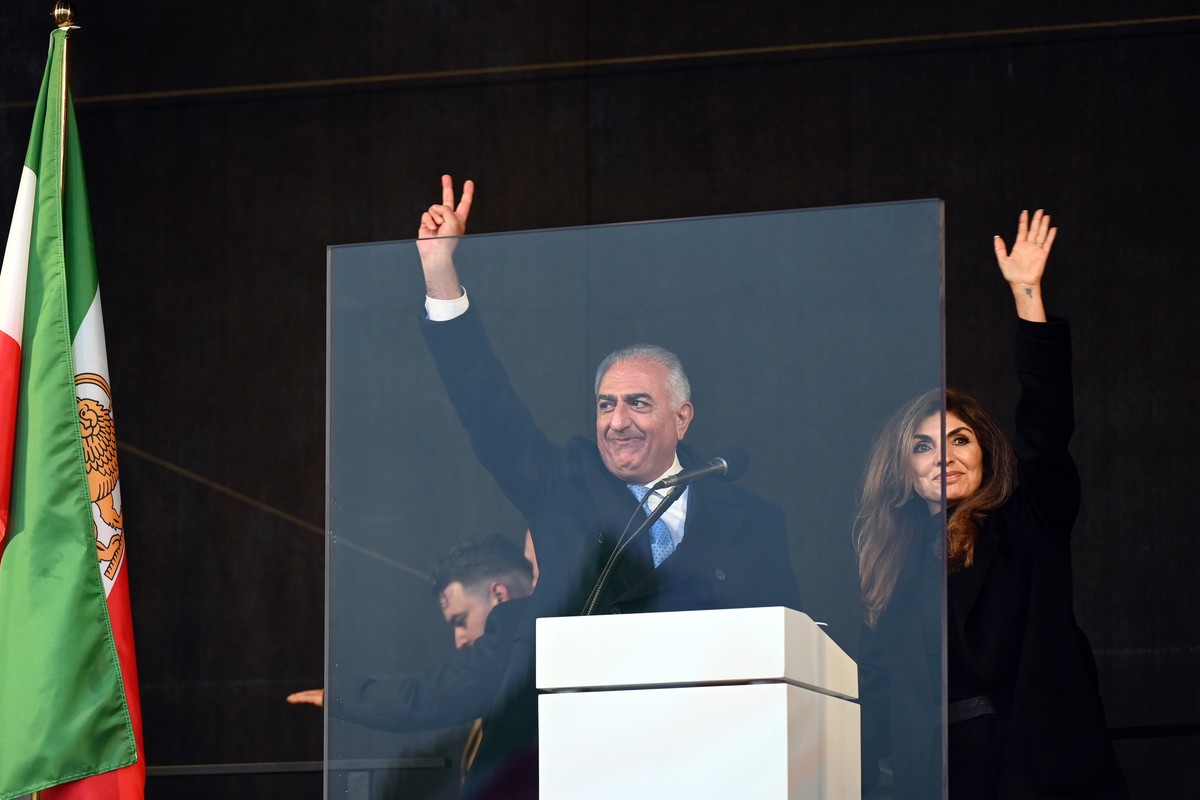 epa12739670 Iranian Crown Prince Reza Pahlavi (C) and his wife Yasmine Pahlavi (R) gesture to supporters during a rally to denounce the Iranian government's crackdown on recent protests and calli ...