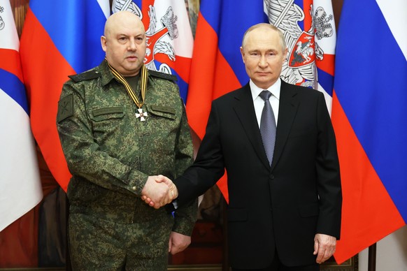 epa10384013 Russian President Vladimir Putin (R) shakes hands with the commander of the Russian military operation in Ukraine, General Sergei Surovikin, awarded the Order of Saint George of the Third Class, ...