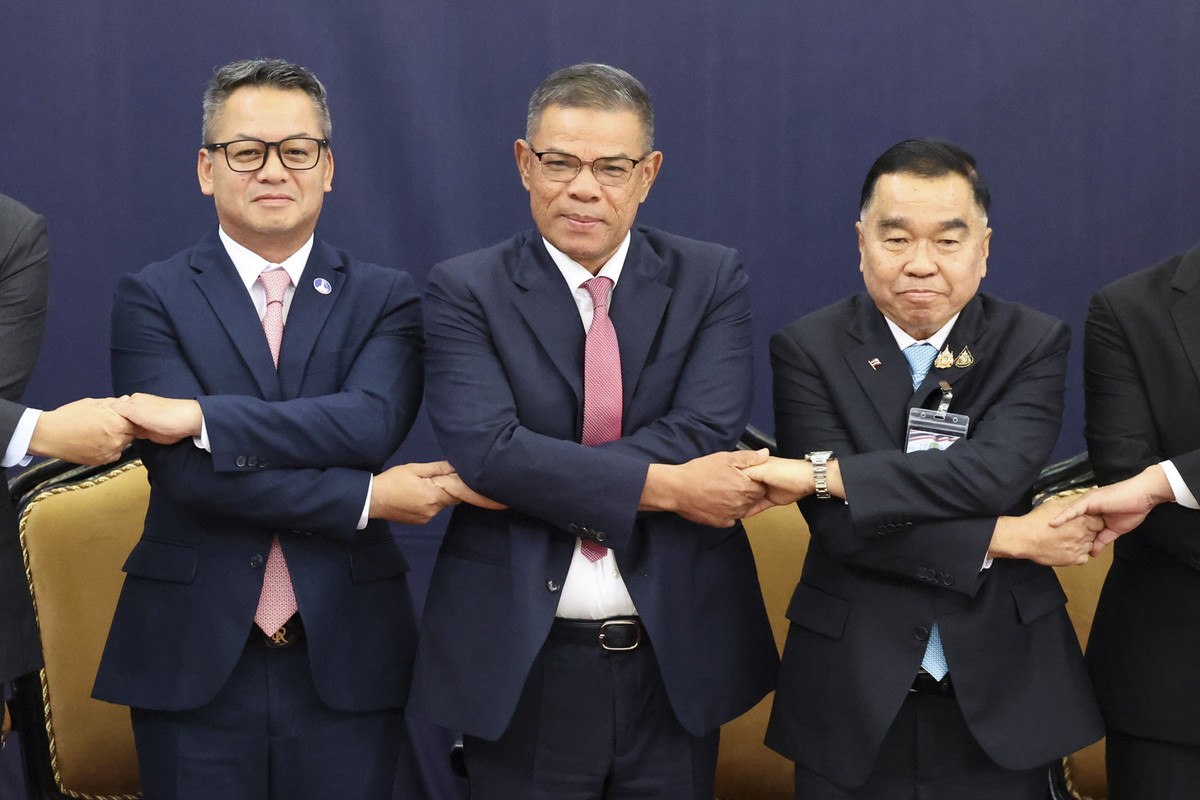 Malaysian Home Minister Saifuddin Nasution Ismail, sixth left, Thai and Cambodian delegates led by Thai Deputy Defense Minister Natthaphon Narkphanit, seventh left, and Cambodian Defense Minister Gene ...