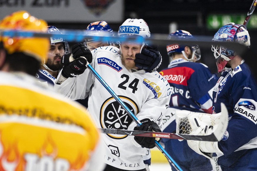 Der Zuercher Phil Baltisberger, links, kaempft um den Puck gegen Luganos Jani Lajunen, Mitte, im sechsten Eishockey Playoff-Finalspiel der National League zwischen den ZSC Lions und dem HC Lugano, am  ...