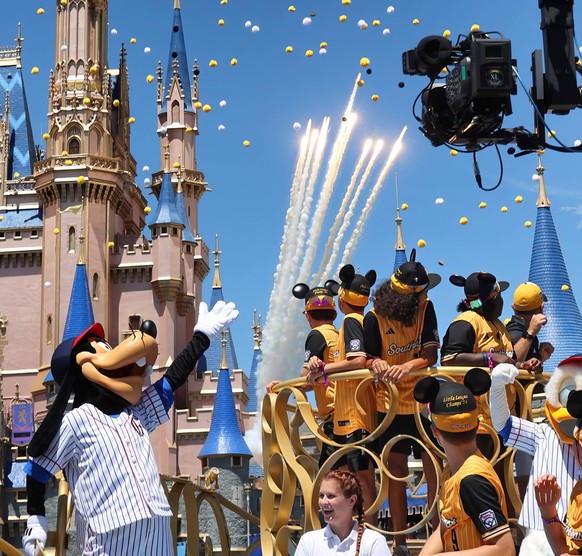 August 29, 2024, Bay Lake, FL, USA - United States: Players on the Little League World Series championship team from Lake Mary, Florida, watch fireworks launch at Cinderella Castle during a parade in  ...