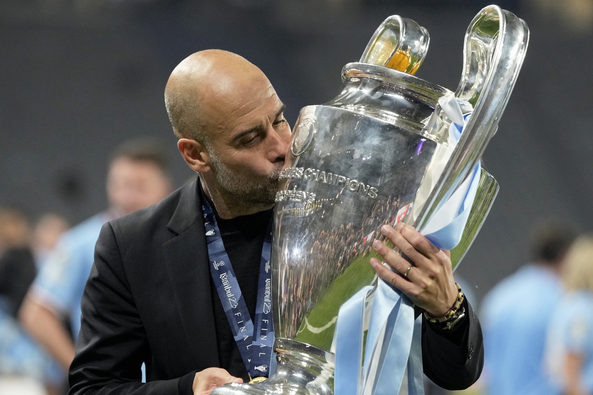 Manchester City's head coach Pep Guardiola kisses the trophy after winning the Champions League final soccer match between Manchester City and Inter Milan at the Ataturk Olympic Stadium in Istanb ...