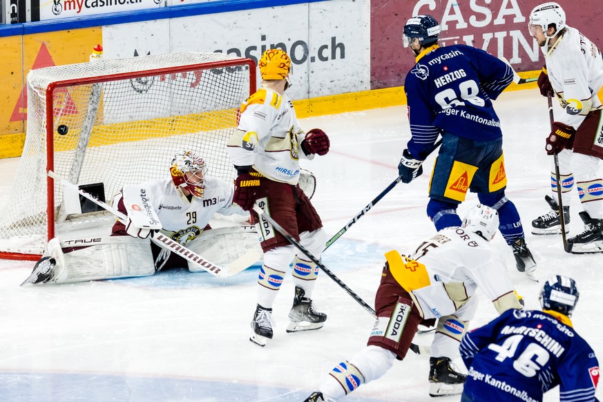 Zugs Lino Martschini, rechts unten, erzielt das Tor zum 1:0 gegen Servettes Torhueter Robert Mayer im vierten Eishockey Playoff Halbfinalspiel der National League zwischen dem EV Zug und Geneve Servet ...