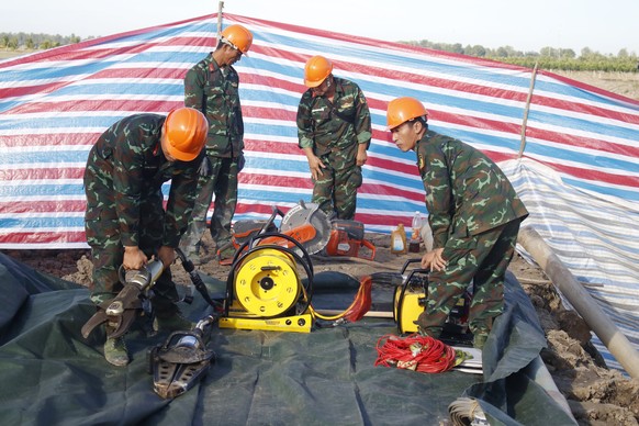 epa10388358 A handout photo made available by the Vietnam News Agency shows soldiers at the site where a 10-year-old boy is stuck in a 35-meter deep hole in in Dong Thap Province, Vietnam, 04 January  ...