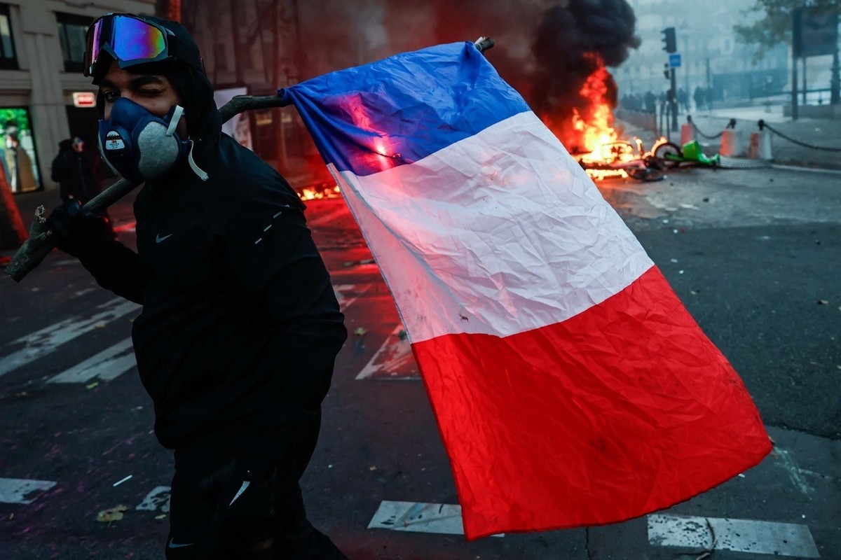 Les émeutes du 17 octobre à Paris. Un émeutier tient un drapeau français