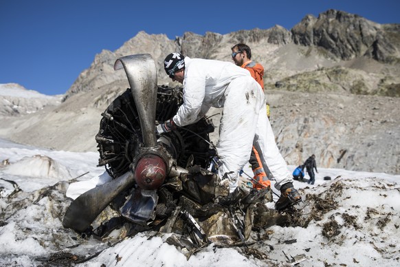 Members of the Swiss army look at a propeller while removing the wreckage of the US-WWII warplane C-53 Skytrooper Dakota that crashed in 1946, pictured on the Gauli Glacier in the Bernese Alps, Switze ...