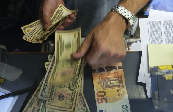 FILE - A cashier changes a 50 Euro banknote with US dollars at an exchange counter in Rome, Wednesday, July 13, 2022. Inflation for the European countries using the euro currency hit another record in ...