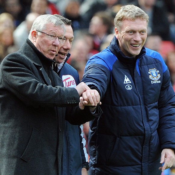 epa04175776 (FILE) File picture dated 22 April 2012 of Manchester United manager Sir Alex Ferguson (left) checks the watch of rival manager Everton&#039;s David Moyes towards the end of the English Pr ...