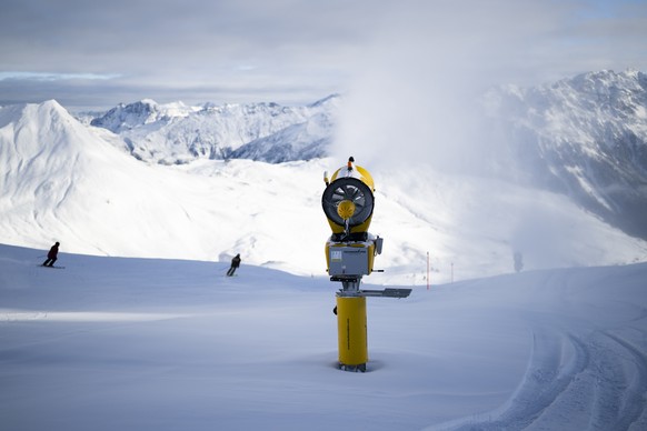 Skifahrer und eine Schneekanone, aufgenommen bei der Eroeffnung der Skisaison, am Samstag, 19. November 2022, auf Parsenn in Davos. (KEYSTONE/Gian Ehrenzeller)