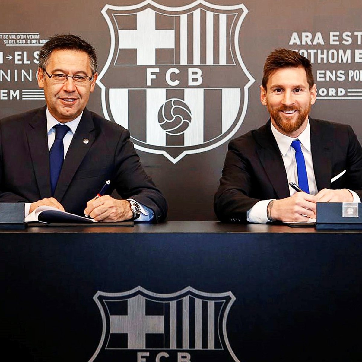 epa06349647 A handout photo made available by Spanish Primera Division soccer club FC Barcelona of Argentine striker Lionel Messi (R) signing his new contract next to Barcelona's president Josep  ...