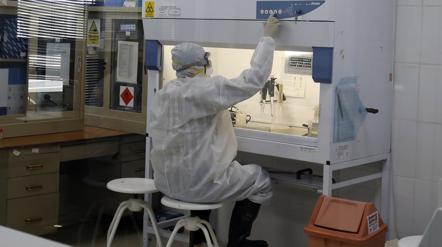 epa08357960 A staff member works on swabs from patients for possible coronavirus infection at the central health laboratory amid the coronavirus pandemic, in Sanaa, Yemen, 11 April 2020, a day after t ...