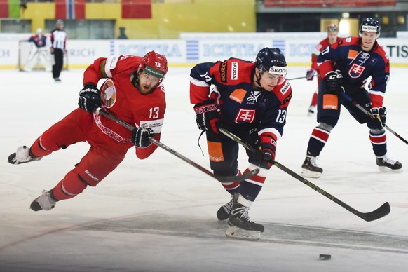 Michal Hlinka of Slovakia, right, and Sergei Drozd of Belarus fight for the puck, during the semifinals of the Arosa Challenge, on Friday, December 18, 2015, in Arosa, Switzerland. (KEYSTONE/Gian Ehre ...