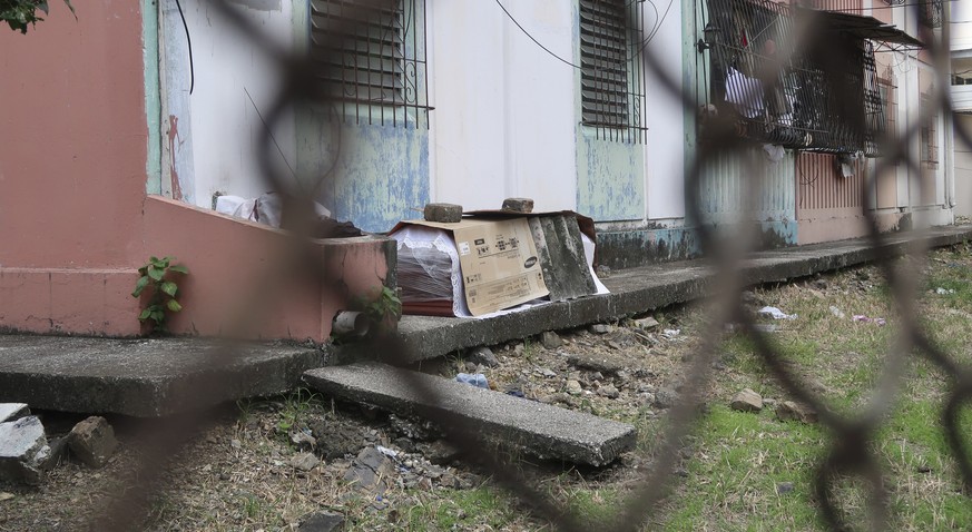 A coffin with the body of a person who is supposed to have died from COVID-19 disease lays wrapped in plastic and covered with cardboard, outside a block of family apartments in Guayaquil, Ecuador, Th ...
