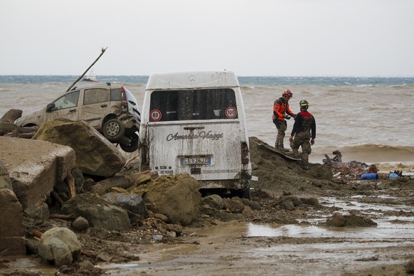 Rescuers stand next to vehicles carried away after heavy rainfall triggered landslides that collapsed buildings and left as many as 12 people missing, in Casamicciola, on the southern Italian island o ...