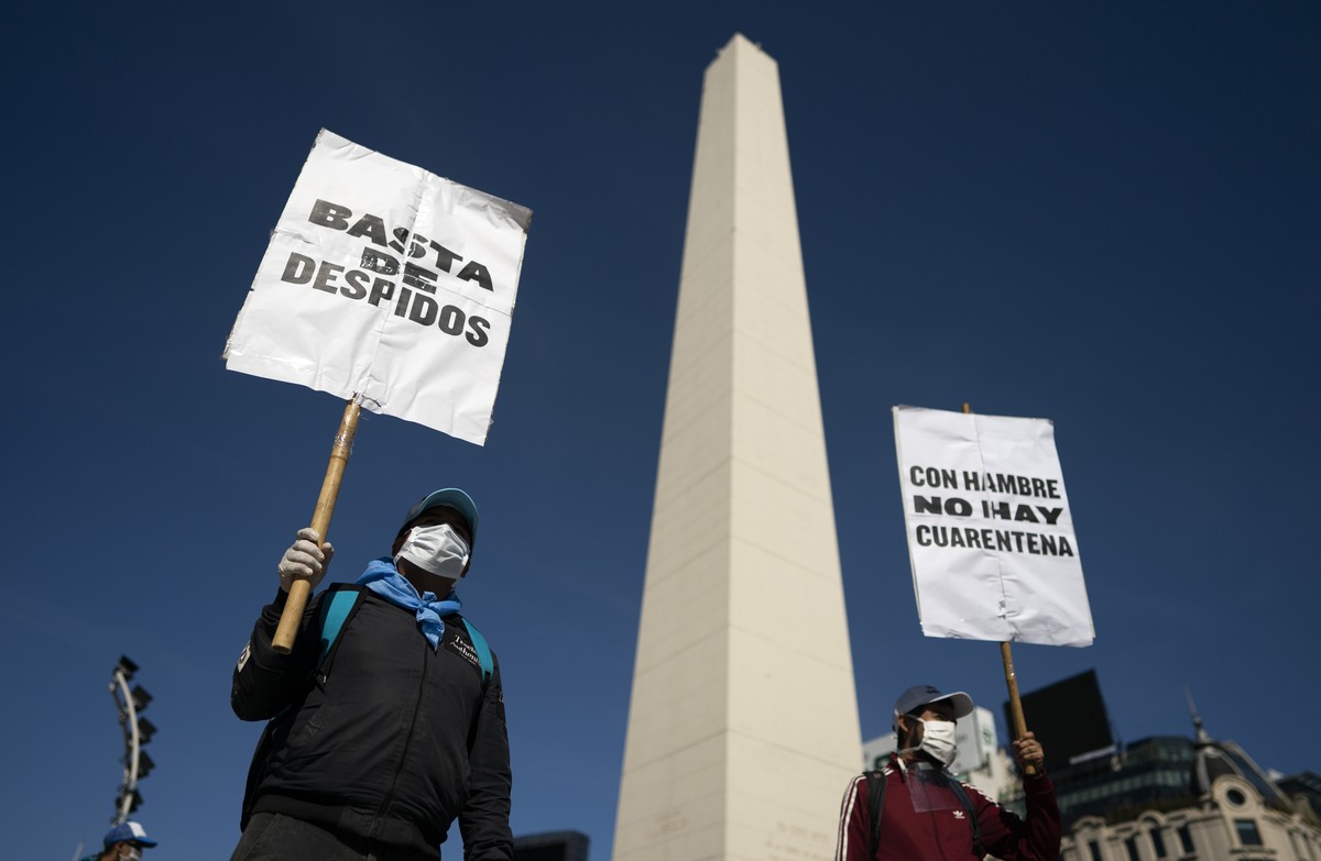Activists demonstrate with signs that read in Spanish "Stop the layoffs" and "With hunger, there is no quarantine" at the Obelisk landmark in Buenos Aires, Argentina, Thursday, Apr ...