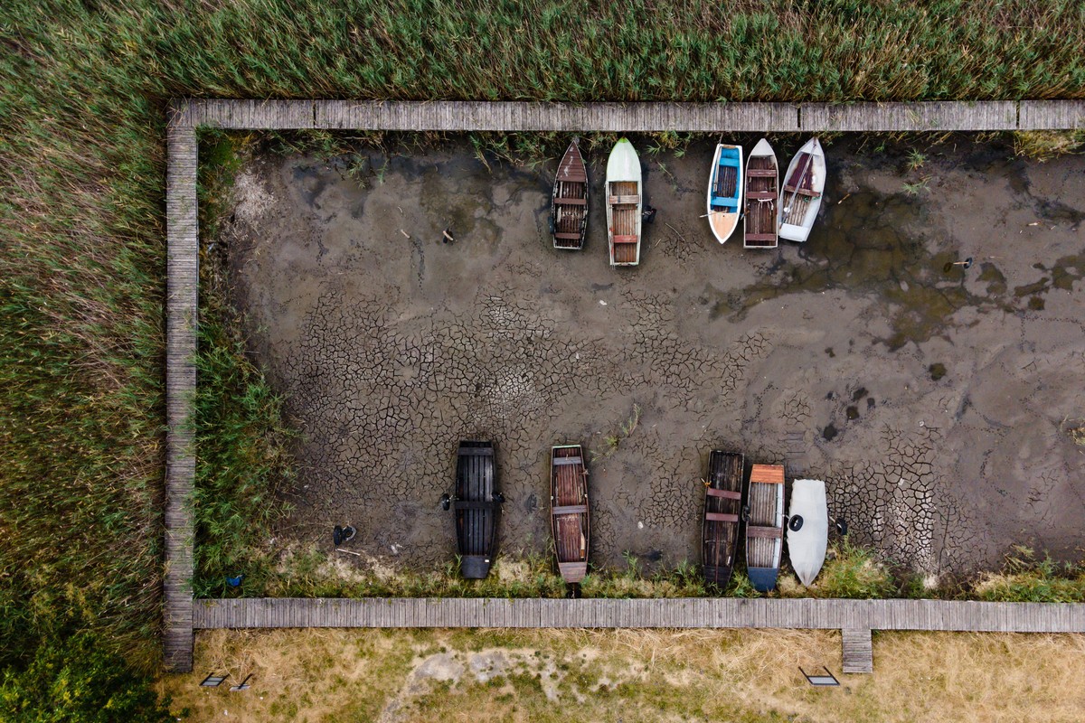 epa10095338 This drone picture shows disused row boats at a dried-out pier of Lake Velence at Pakozd, Hungary, 28 July 2022. A popular holiday destination for domestic visitors, Hungary���s third larg ...