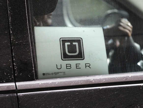 FILE - An Uber car drives through LaGuardia Airport in New York, March 15, 2017. Two taxi drivers have been arrested in the Mexican city of Cancun for assaulting a van carrying foreign tourists. The e ...