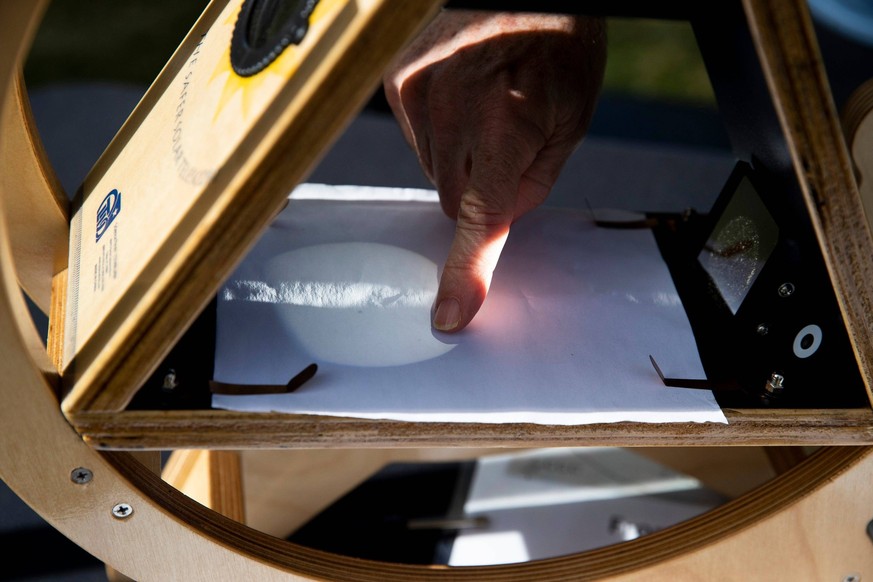 Syndication: The Commercial Appeal Jim Silda, with the National Oceanic and Atmospheric Administration, points to a sun spot that can be seen on the surface of the sun through a sun spotter on Arlingt ...
