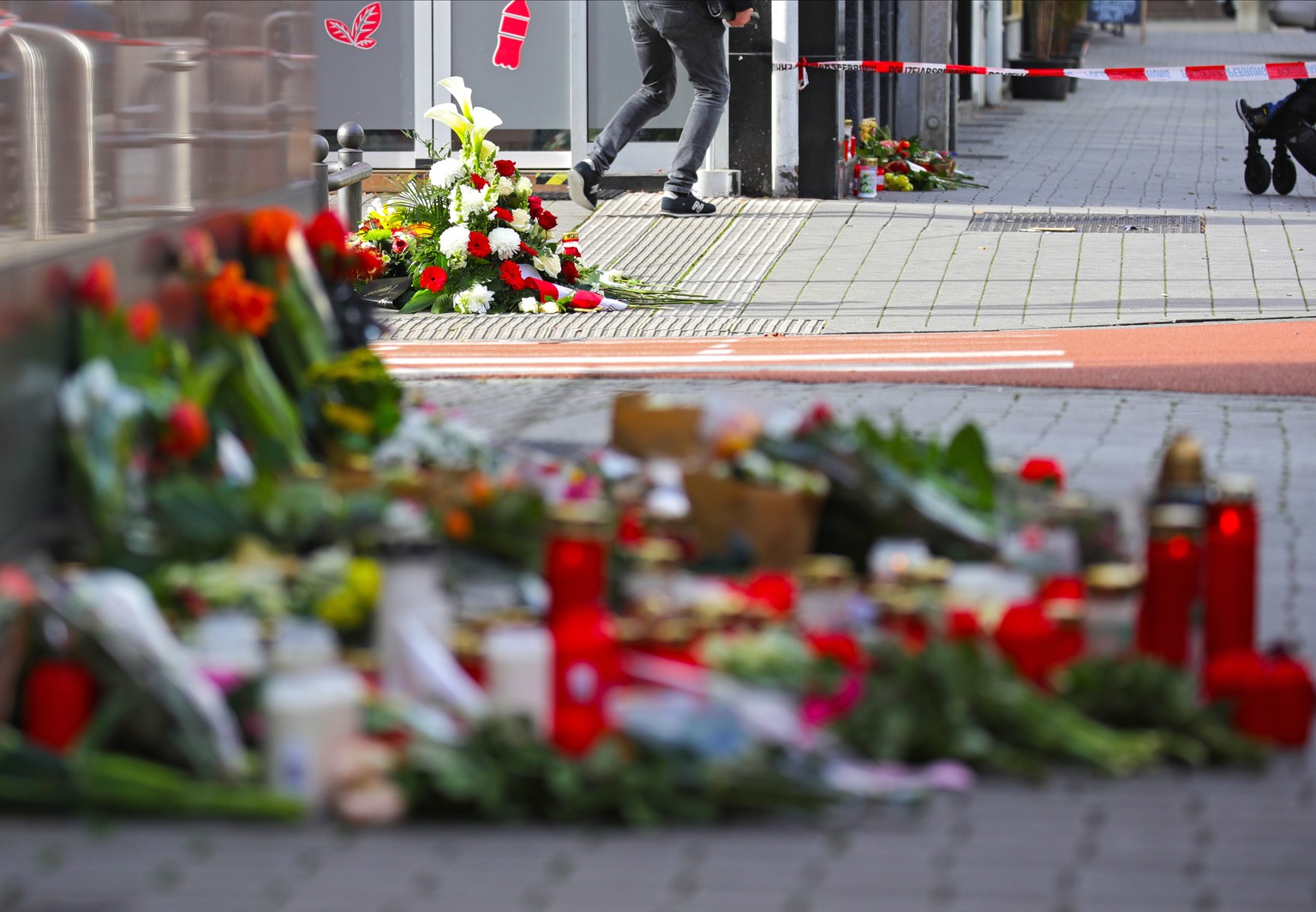 epa08234130 Flowers and candles have been placed at a makeshift memorial for the racist terror attacks in Hanau, Germany, 21 February 2020. At least nine people were killed in two shootings at shisha  ...