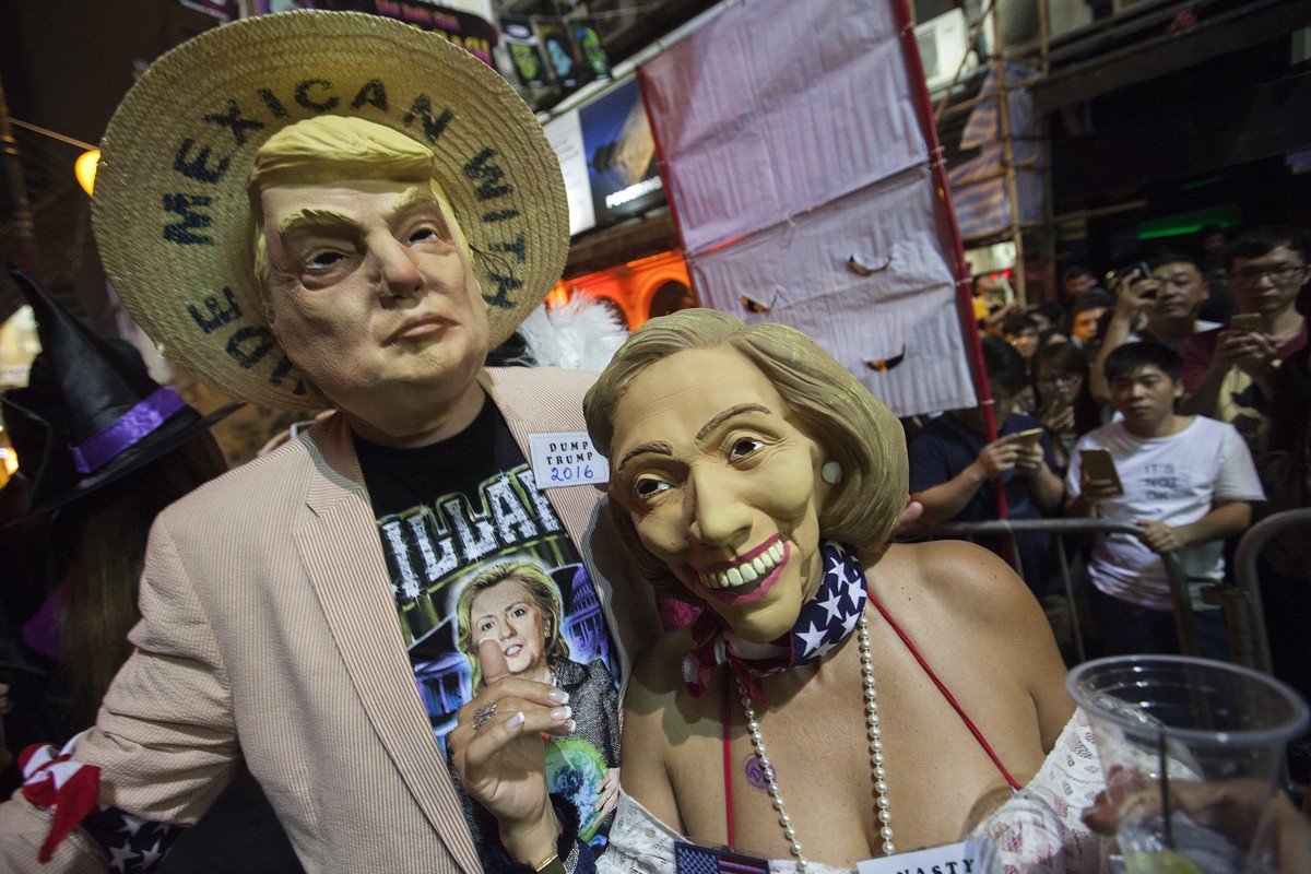 epa05611585 People dressed up as US Republican presidential candidate Donald Trump (L) and US Democratic presidential candidate Hillary Clinton for Halloween celebrate in Hong Kong's popular bar  ...