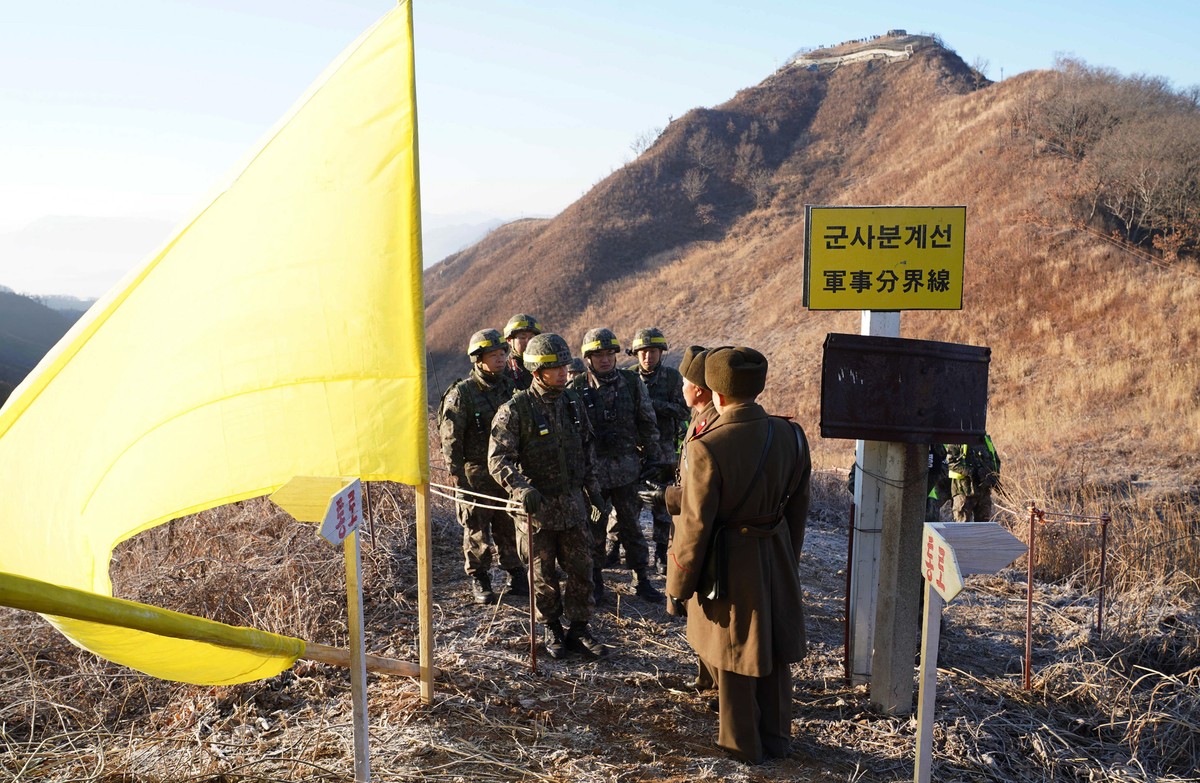 FILE - In this photo provided by South Korea Defense Ministry, South Korean army soldiers, wearing helmets, prepare to cross the Military Demarcation Line as North Korean army soldiers stand inside th ...