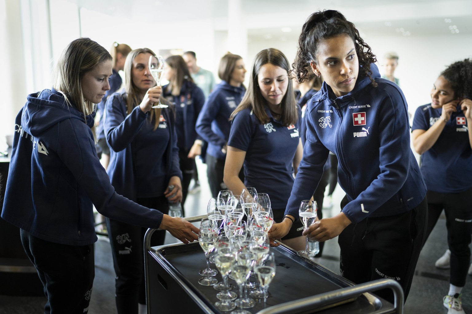 Die Spielerinnen und der Staff der Schweizer Frauen Fussballnationalmannschaft stossen mit Champagner an, um die Entscheidung der uefa zu feiern, die UEFA Woman&#039;s EURO 2025 an die Schweiz zu verg ...