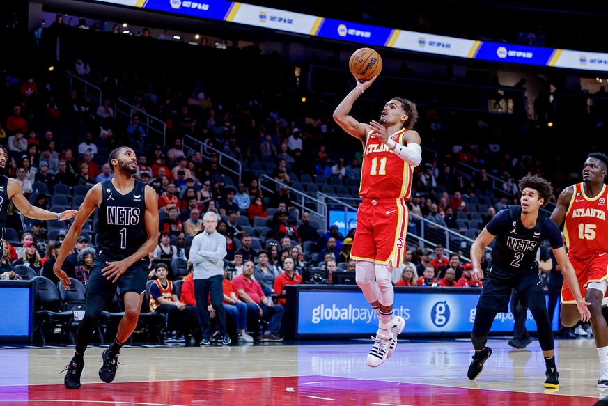 epa10493108 Atlanta Hawks guard Trae Young (C) in action against Brooklyn Nets forward Mikal Bridges (L) and Nets forward Cameron Johnson (R) during the first half of the NBA basketball game between t ...