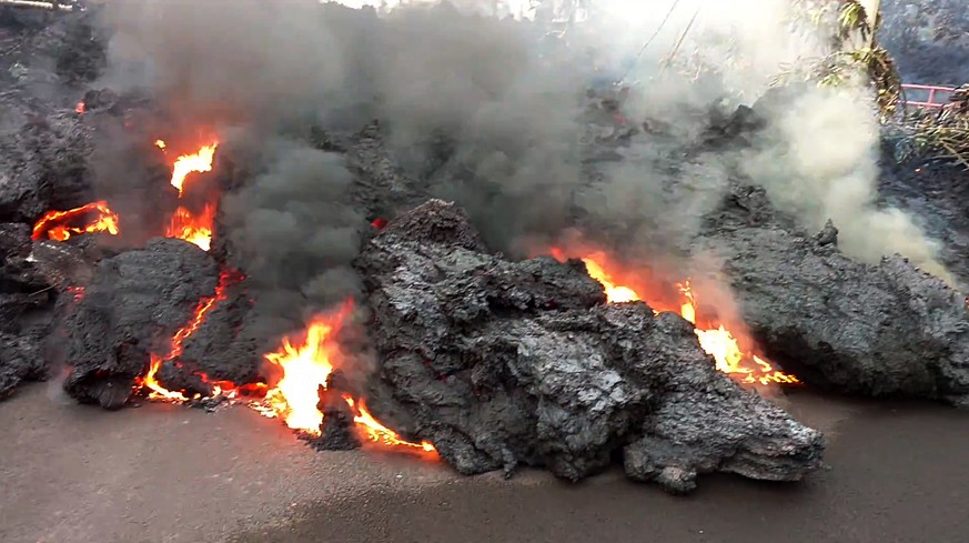 In this photo from video a lava flow advancing down a road is seen from less than 10 feet away in the Leilani Estates subdivision near Pahoa on the island of Hawaii Monday, May 7, 2018. Kilauea volcan ...