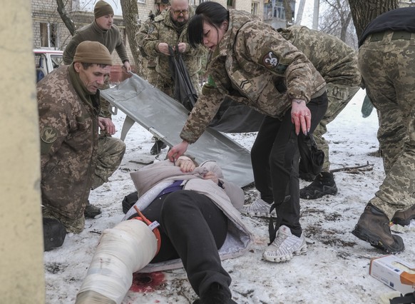 epa10444414 Medical workers help an injured woman at the site of a rocket attack on a residential area in Kramatorsk, Donetsk region, eastern Ukraine, 02 February 2023, amid Russia&#039;s invasion. At ...