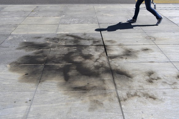 Brandspuren auf dem Bundesplatz vor dem Bundeshaus in Bern, nachdem sich eine Person an einer Demonstration gegen die Asylpolitik selbst angezuendet hatte, am Montag, 20. Juli 2020. (KEYSTONE/Anthony  ...