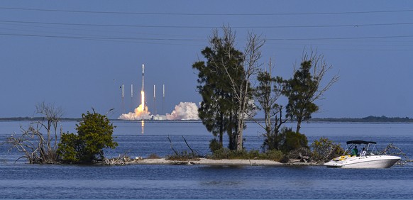 People along the Beachline by the Banana River in Port Canaveral, Fla., view the launch of a SpaceX Falcon 9 rocket carrying a SiriusXM&#039;s SXM-7 satellite, Sunday, Dec. 13, 2020. The rocket was la ...