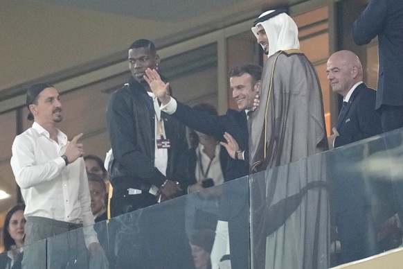 France&#039;s President Emmanuel Macron waves next to soccer players Zlatan Ibrahimovic, left, from Sweden and Paul Pogba, 2nd left, from France, on the tribune ahead of the World Cup final soccer mat ...