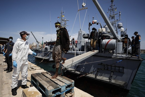 epa10692625 Migrants arrive to the harbor of the Sicilian island of Lampedusa (Agrigento) after being rescued by a Guardia di Finanza ship to be transferred to Lampedusa immigrant reception facility,  ...