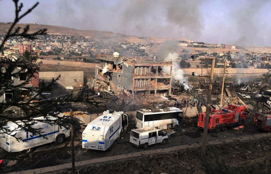 Smoke still rises from the scene after Kurdish militants attacked a police checkpoint in Cizre, southeast Turkey, Friday, Aug. 26, 2016, with an explosives-laden truck, killing several police officers ...