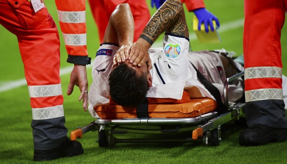 Italy&#039;s Leonardo Spinazzola covers his face after injuring during the Euro 2020 soccer championship quarterfinal match between Belgium and Italy at at the Allianz Arena in Munich, Germany, Friday ...